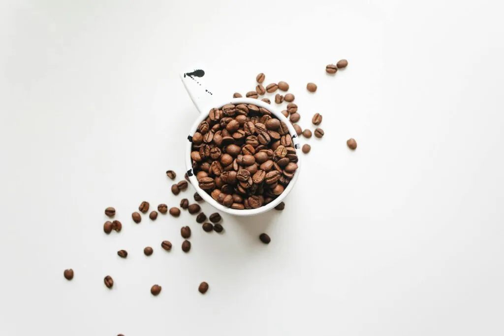 white ceramic mug full of espresso coffee beans for latte recipe