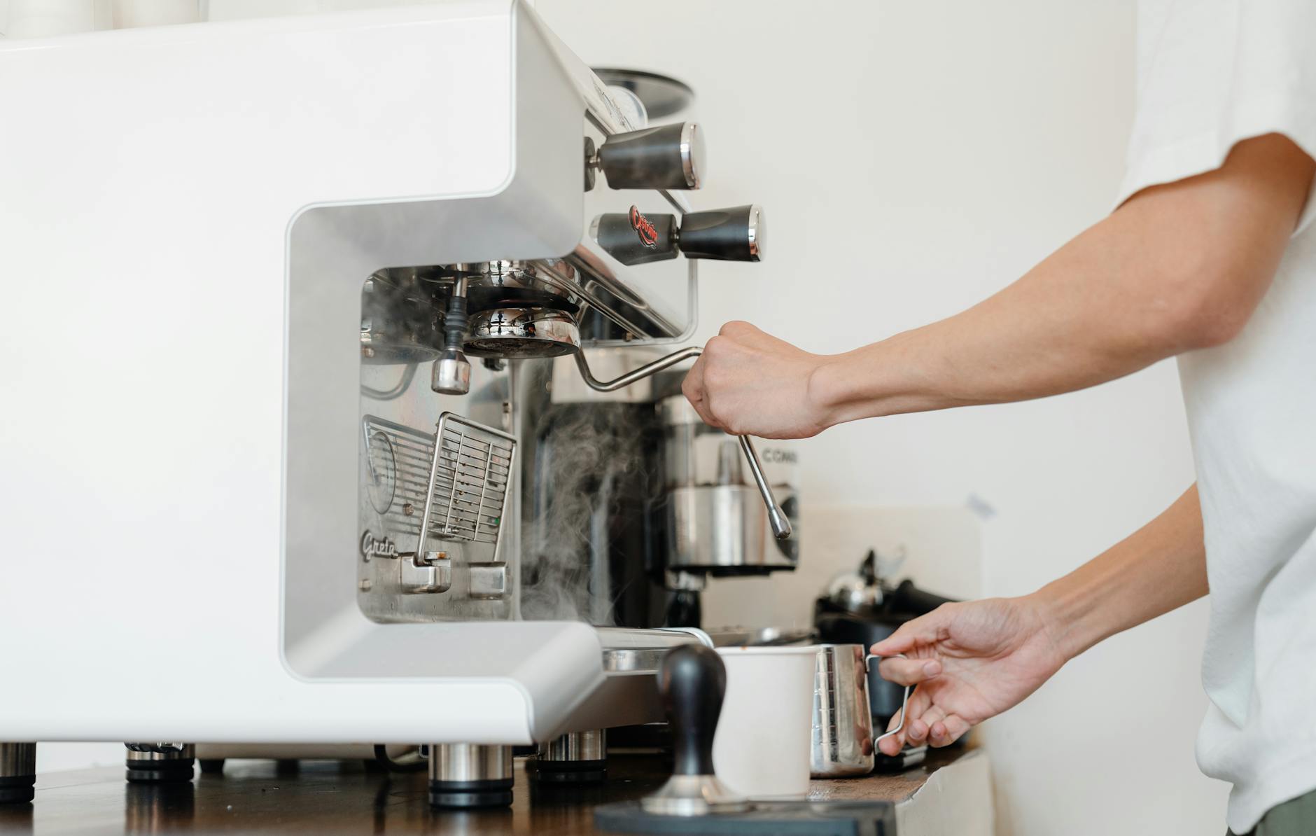 crop barista with jigger and coffee machine cappuccinator