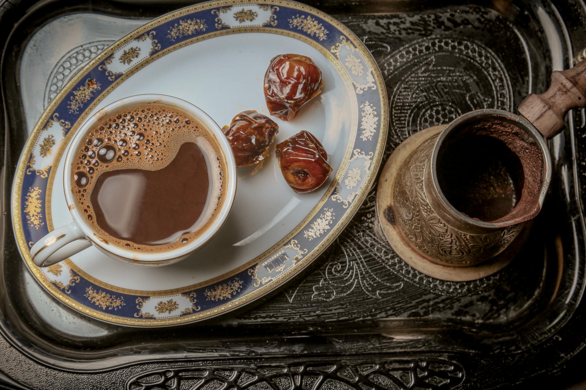 cup of coffee with dates on a serving tray