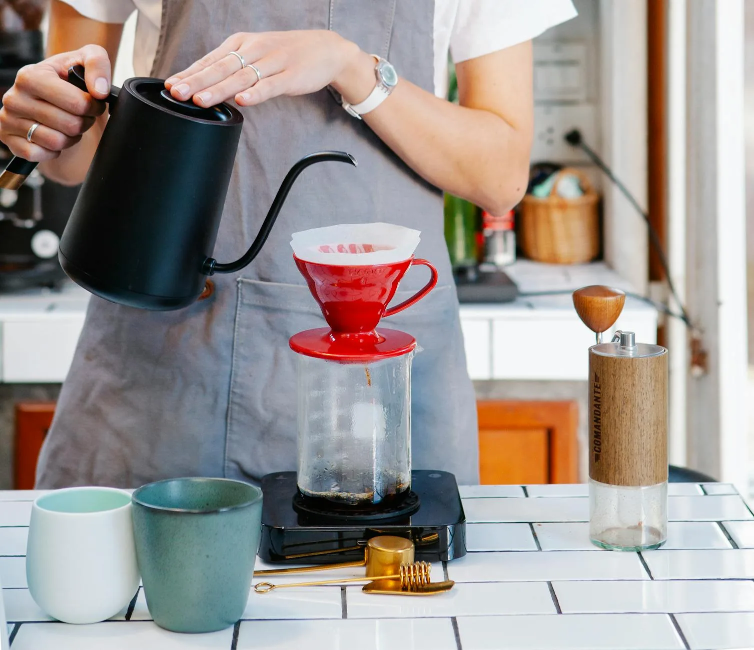 female barista using filter drippers while pouring fresh coffee - pour-over coffee - Fair Coffee Blog - coffee drink recipes
