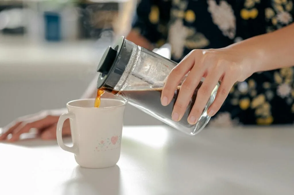 woman pouring coffee to a mug