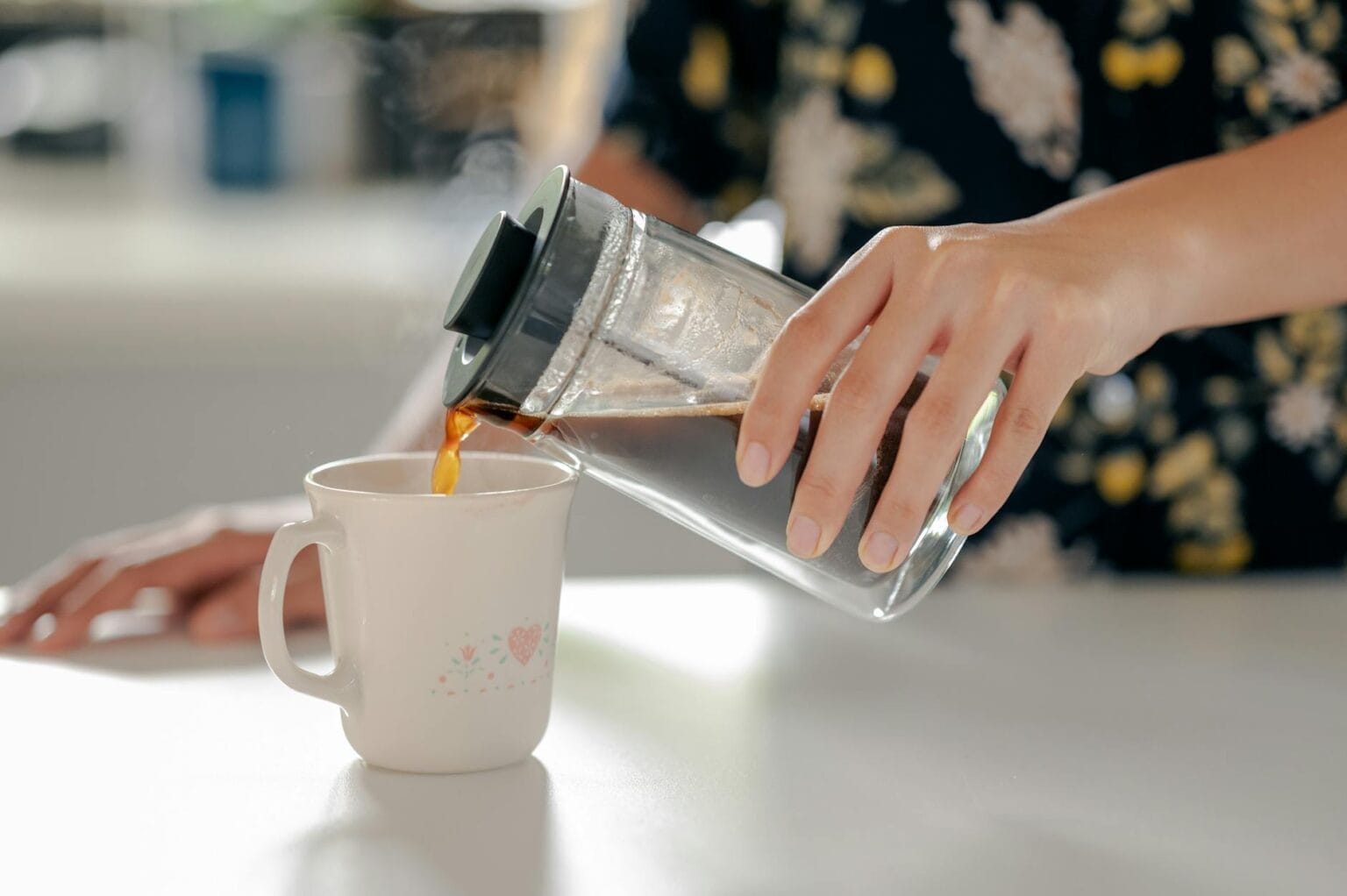 woman pouring coffee to a mug