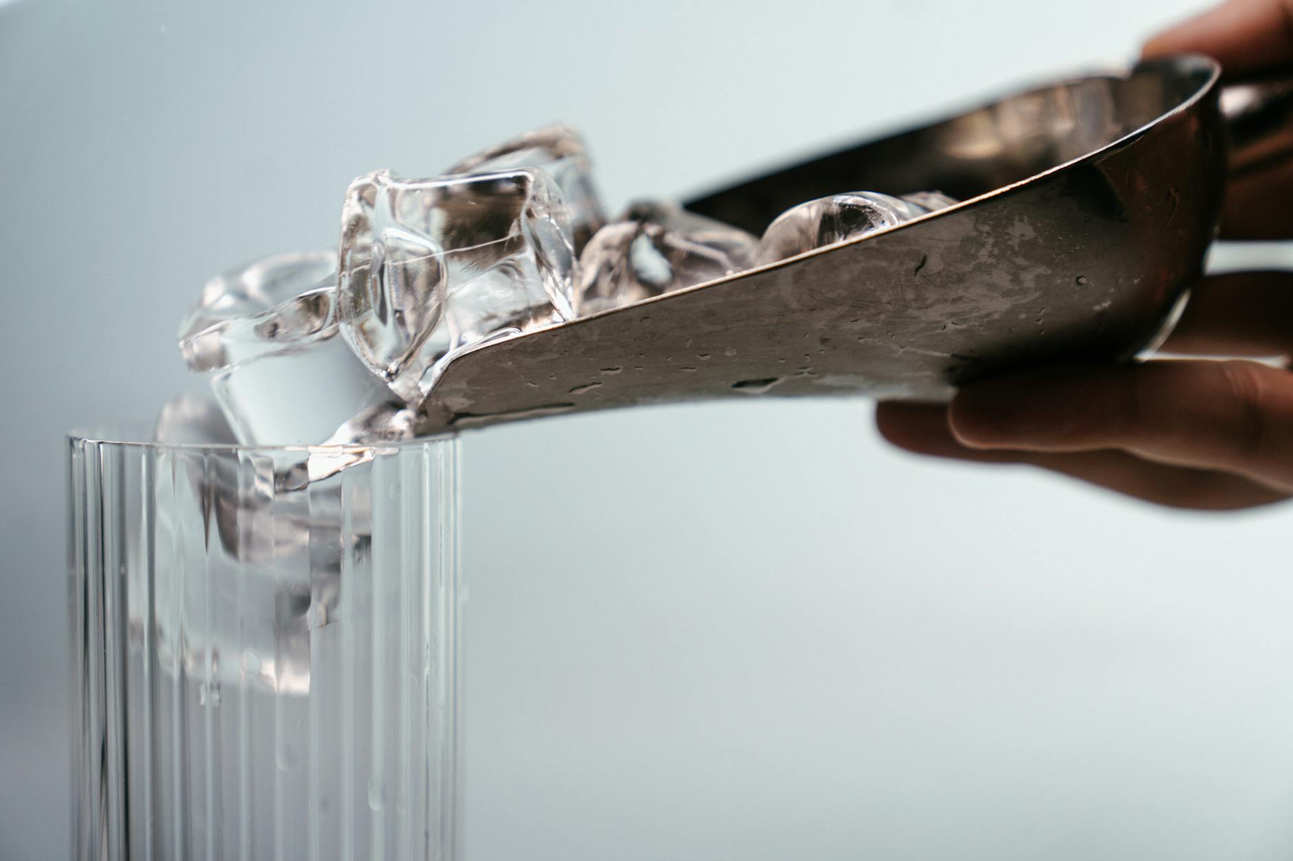 person holding clear glass mug