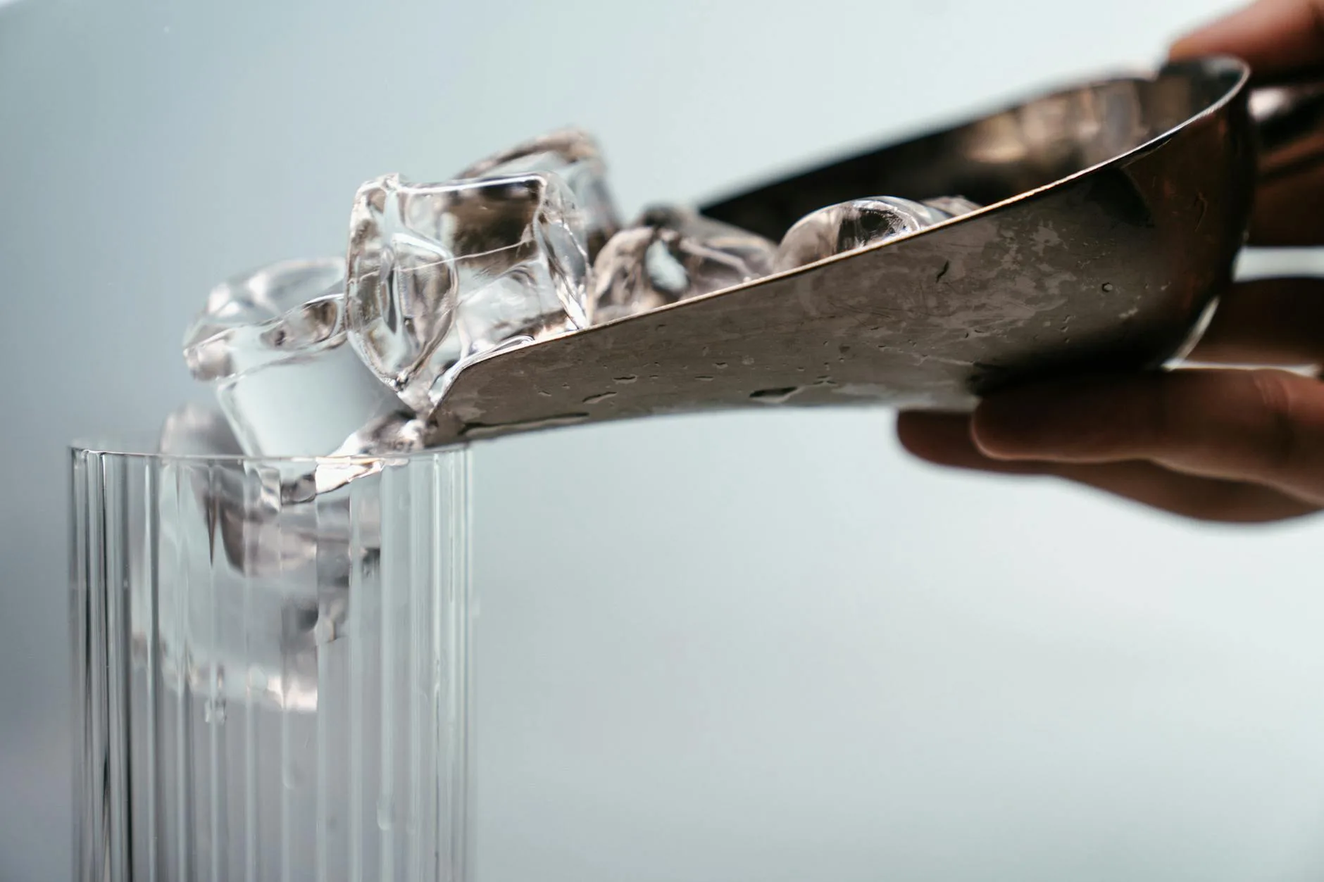 person holding clear glass mug