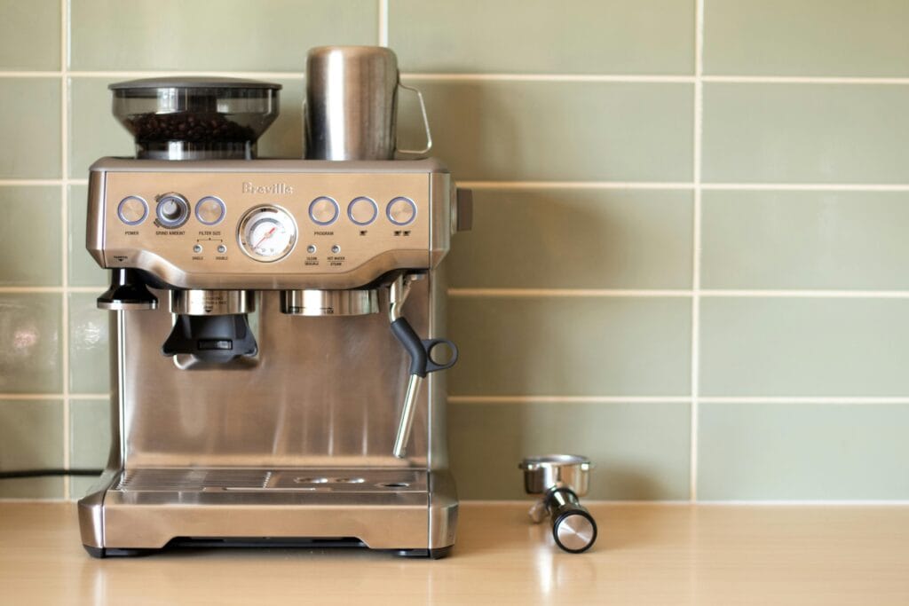 coffee price 2024 - Modern espresso machine with push buttons and gauge, blending technology and convenience in a stylish kitchen setting.