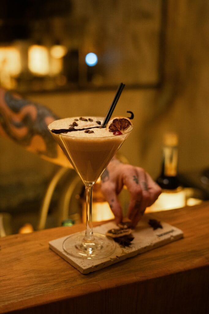 vanilla non-alcoholic espresso martini cocktail - coffee drinks - coffee recipe - with elegant presentation at a stylish bar, captured with a tattooed bartender.