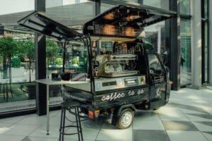 A stylish mobile coffee van serving espresso in a modern urban environment.