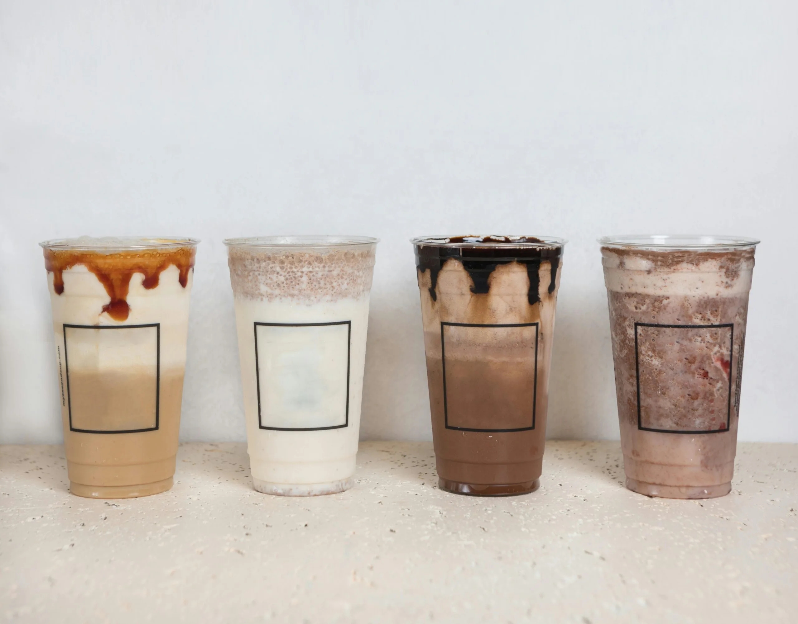 Cold brew coffee A variety of iced coffee beverages in clear plastic cups, showcasing different flavors and layers.
